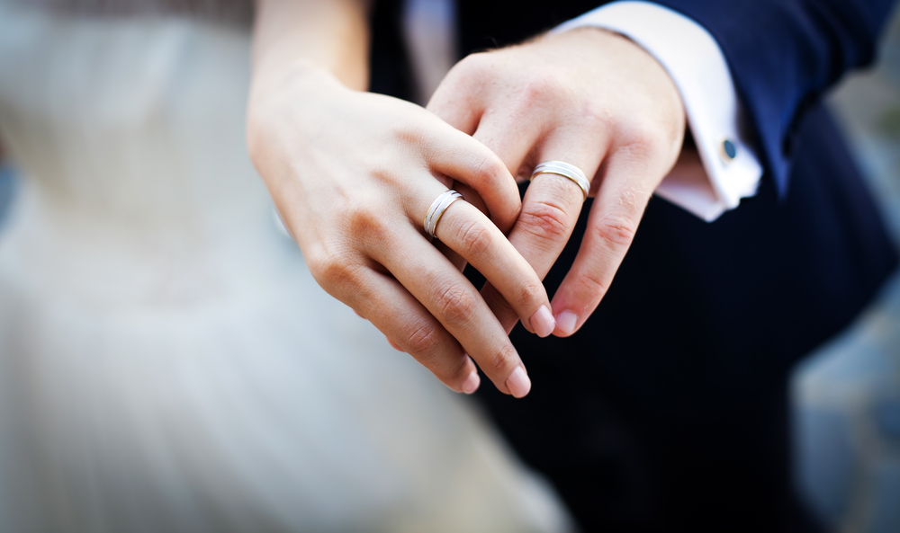 A married couple holding hands, symbolizing divorced employees