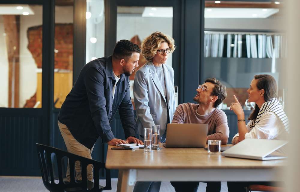 An image of employees discussing financial stress.